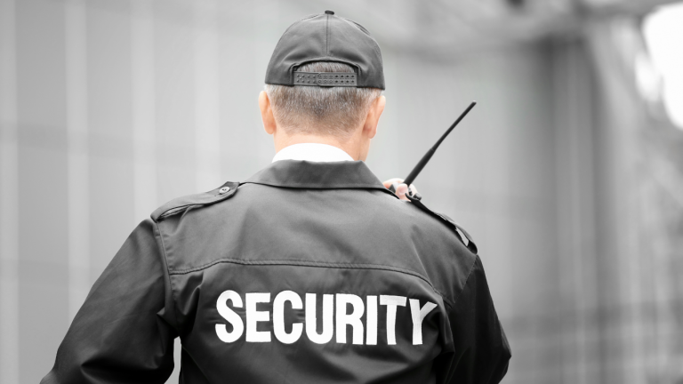 Coldwell Banker México muestra un punto de control de seguridad en la entrada de una comunidad cerrada, con guardias y cámaras de vigilancia.